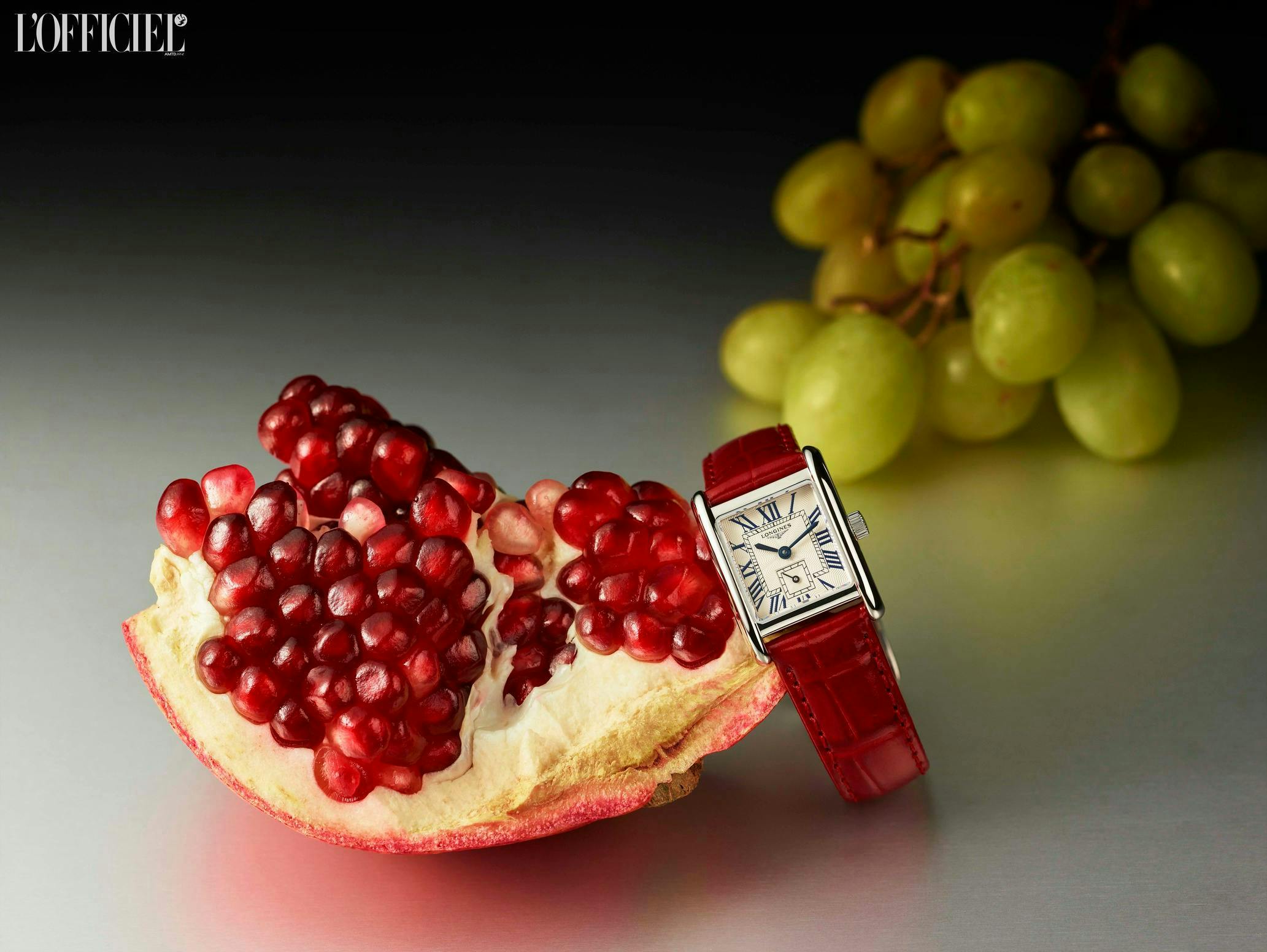 pomegranete and green grapes next to longines watch