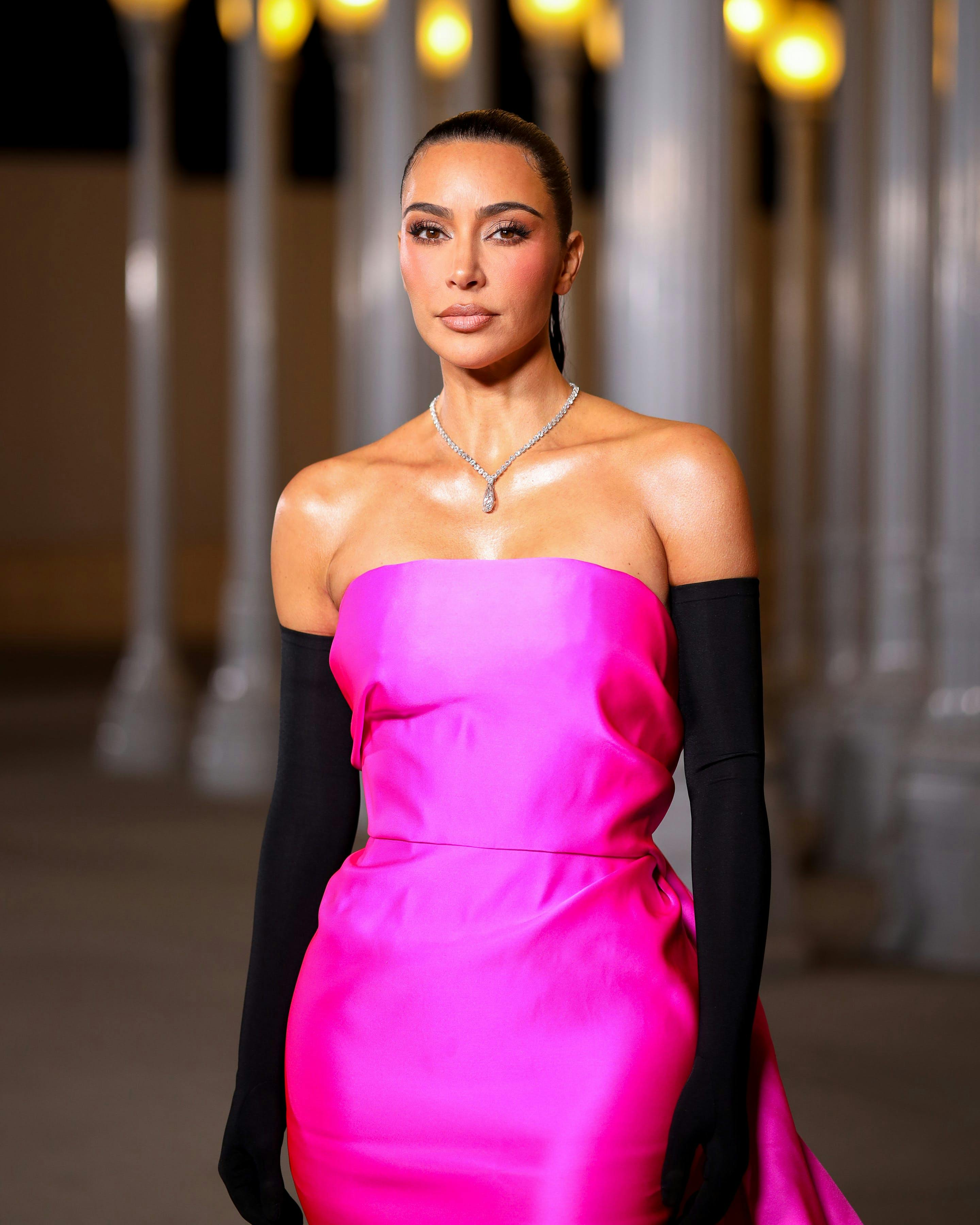 kim kardashian in a pink gown looking at the camera