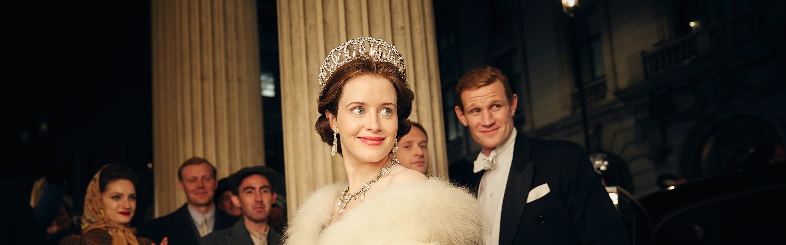 claire foy in white dress, tiara, long gloves, and fur next to matt smith wearing a tuxedo