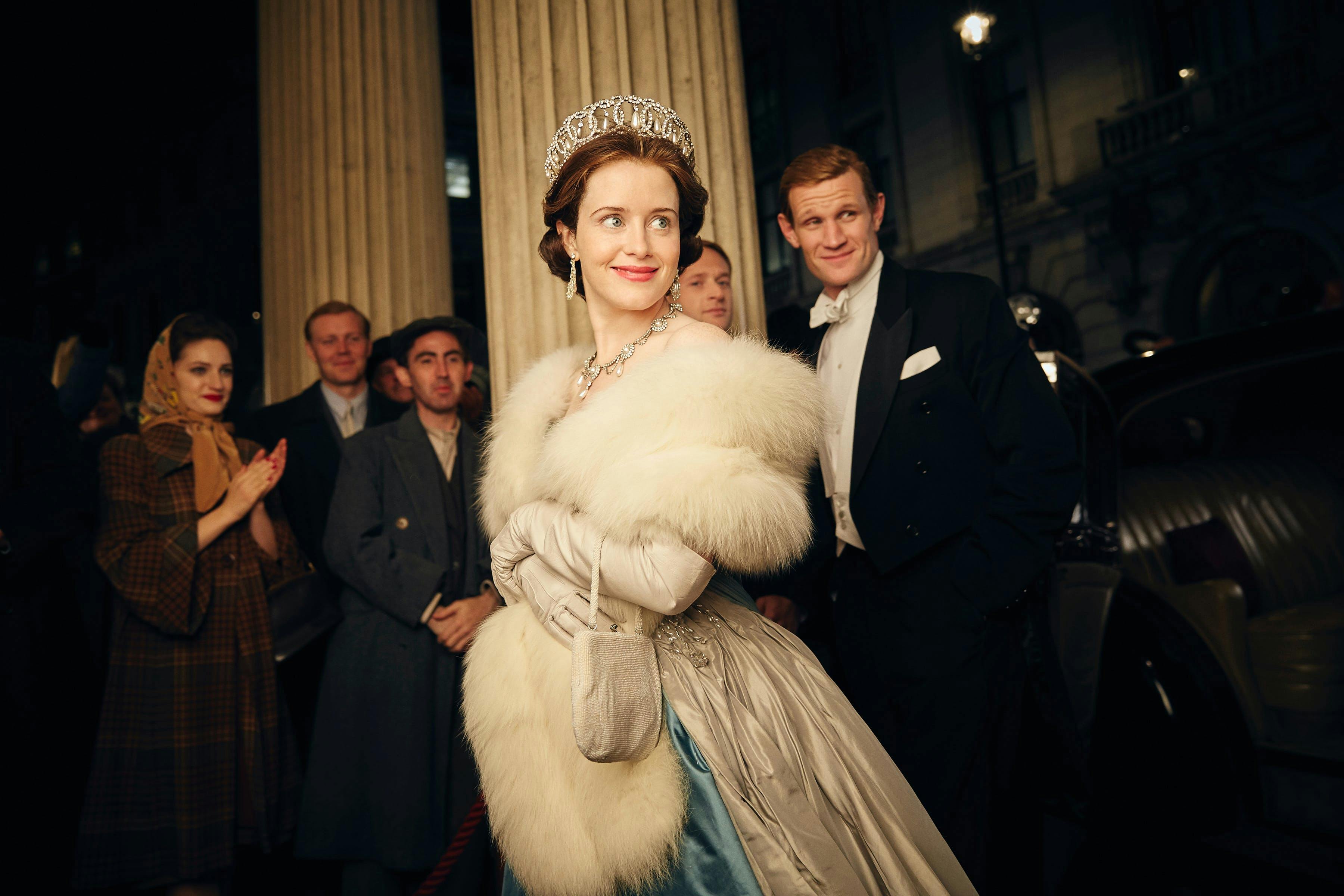 claire foy in white dress, tiara, long gloves, and fur next to matt smith wearing a tuxedo