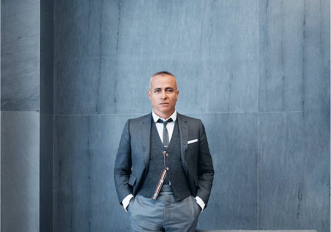Thom Browne standing in a gray suit  top and shorts