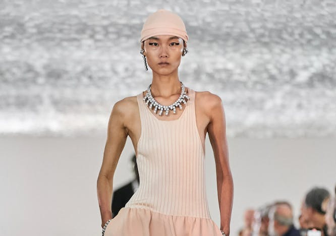 model on runway wearing peach outfit