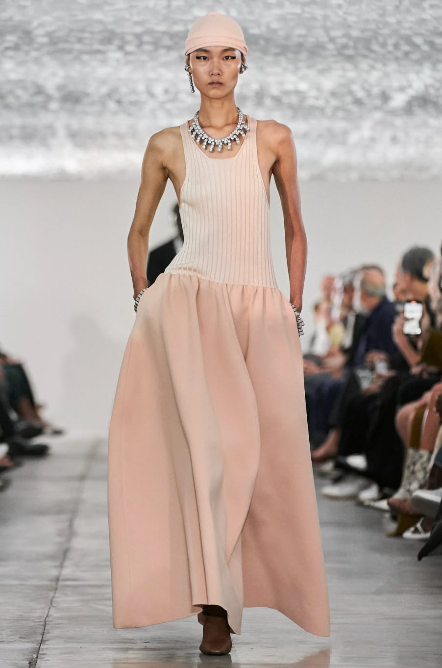 model on runway wearing peach colored dress