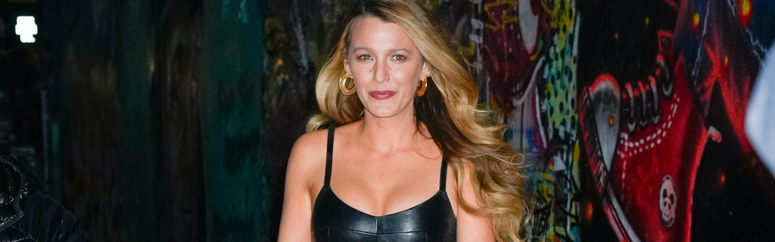 blake lively walking down street at night wearing leather dress and gold jewelry