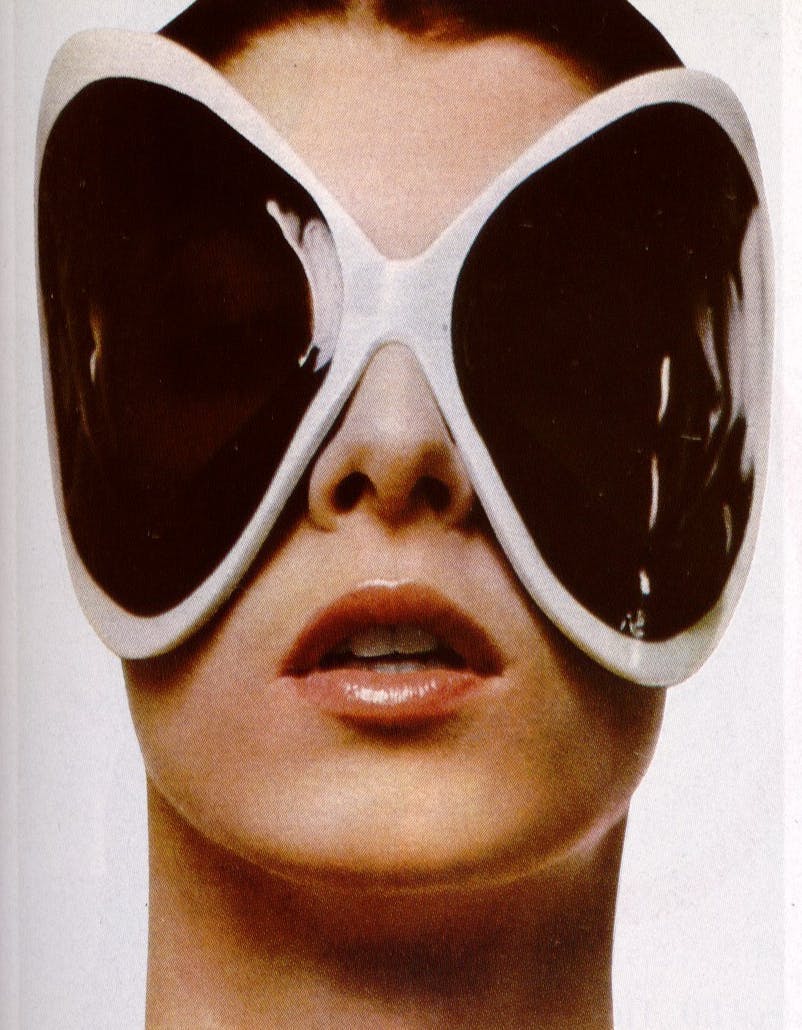 a woman wearing large shield sunglasses bug-eye in white.