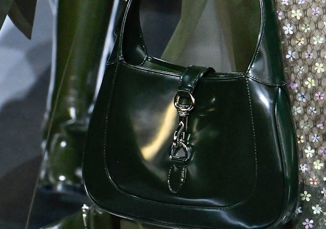 olive green fall/winter 2024 color trend: closeup of accessory details on gucci fall/winter 2024; iconic gucci jackie handbag in olive green